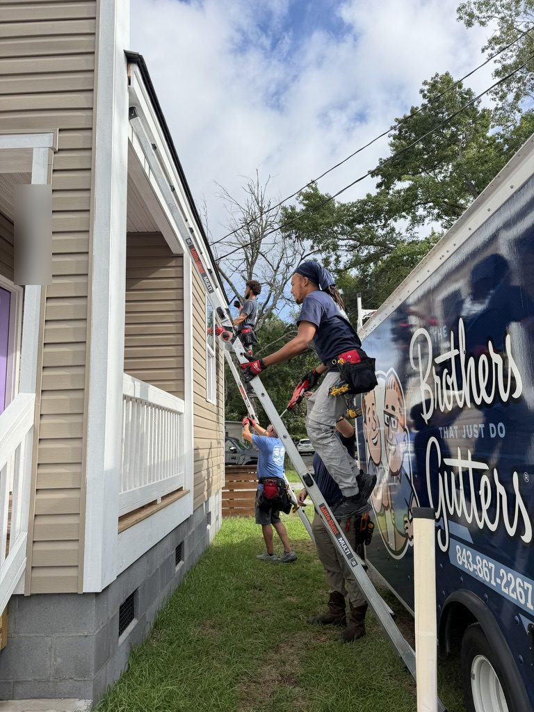 Brothers Gutters Charleston crew on ladders installing gutters