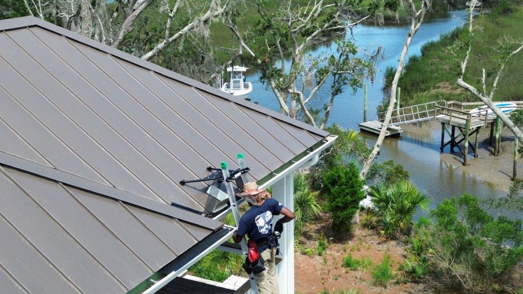 Gutter installation on a metal roof home near the Lowcountry marsh